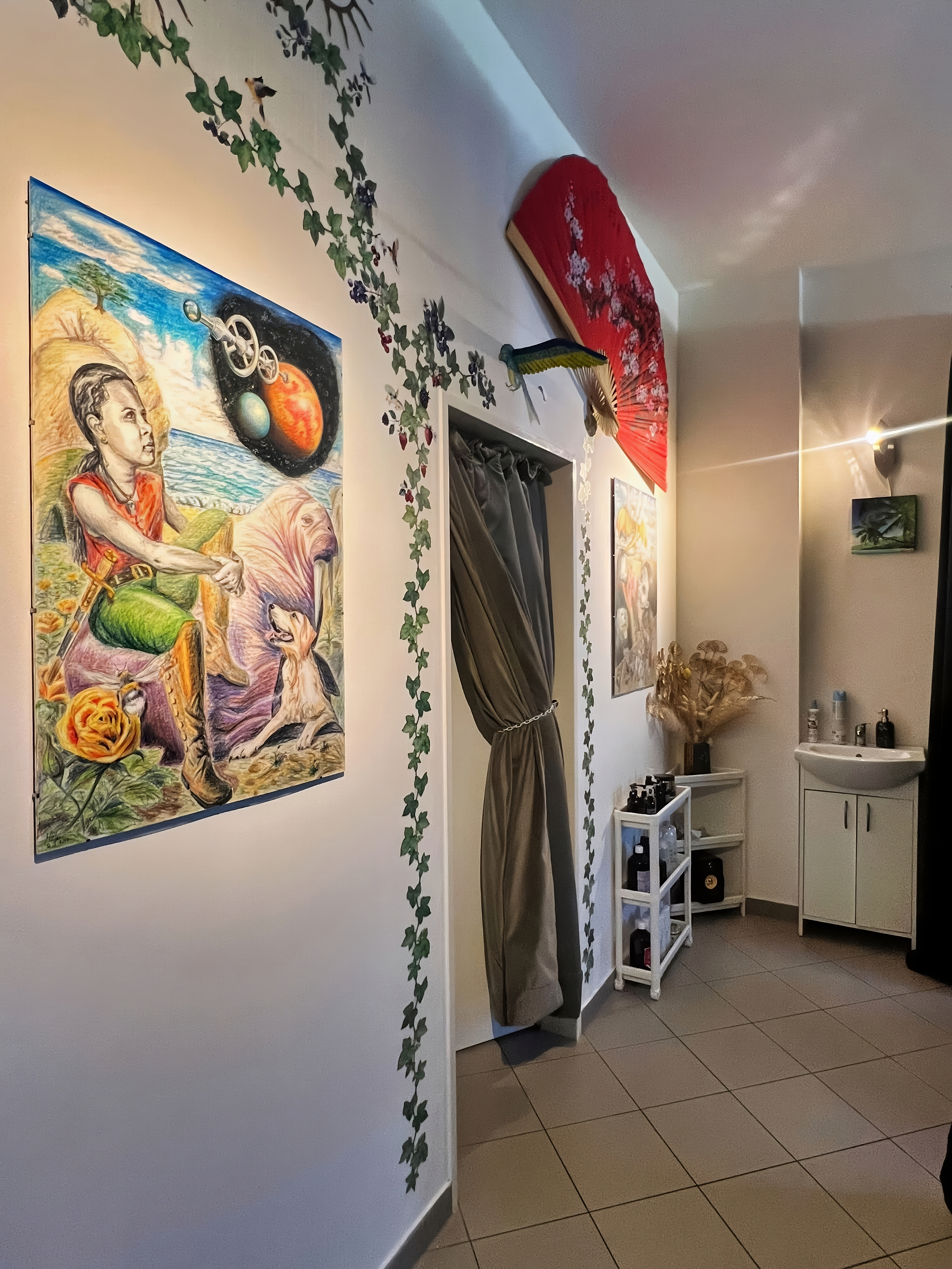 Chodba salonu s uměleckými obrazy a břečťanem